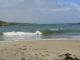 lien photo 5 - Petite vague déferlant sur une plage.